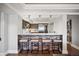 View of the modern bar featuring brickwork, barstool seating and views of the open kitchen space at 1891 Curtis St # 1812, Denver, CO 80202