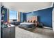 Stylish bedroom with bold blue walls, a plush bed, and a large window offering a scenic view at 1891 Curtis St # 1812, Denver, CO 80202