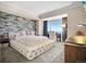 Bright main bedroom featuring tufted bed, accent wall, and beautiful window view at 1891 Curtis St # 1812, Denver, CO 80202