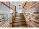 Modern staircase design with wooden steps, metal railings, and accent brick wall at 1891 Curtis St # 1812, Denver, CO 80202