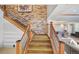 Staircase leading to a living room with brick accent wall and modern metal railings at 1891 Curtis St # 1812, Denver, CO 80202