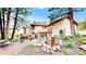 Large home backyard with stone water feature, exterior lighting, outdoor seating, dining, and a hot tub at 974 Spring Ranch Dr, Golden, CO 80401