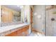 Bathroom featuring a marble countertop, a walk-in shower, and warm lighting at 974 Spring Ranch Dr, Golden, CO 80401