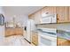 Basement kitchen with white appliances, light wood cabinets, and granite countertops at 974 Spring Ranch Dr, Golden, CO 80401