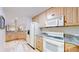Basement kitchenette featuring light wood cabinetry, granite countertops, and modern white appliances at 974 Spring Ranch Dr, Golden, CO 80401