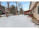 Snowy backyard with trees and partially visible fence at 89 Dawn Heath Cir, Littleton, CO 80127