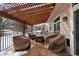 Relaxing backyard deck with pergola, seating area, and snow covered yard at 89 Dawn Heath Cir, Littleton, CO 80127