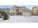 Two-story house with brick and siding, snow-covered lawn, and a two-car garage at 89 Dawn Heath Cir, Littleton, CO 80127