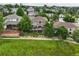 Aerial view of home surrounded by mature trees, neighboring homes, and a pond at 15962 W 70Th Dr, Arvada, CO 80007