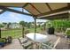 Covered back deck with seating and views of the green backyard and neighborhood at 15962 W 70Th Dr, Arvada, CO 80007
