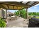 Covered back deck with seating and dining area and an outdoor grill at 15962 W 70Th Dr, Arvada, CO 80007