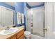 Light blue bathroom with vanity, toilet, and glass shower at 15962 W 70Th Dr, Arvada, CO 80007
