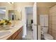 Bathroom featuring a double sink vanity and the entry to a water closet with toilet at 15962 W 70Th Dr, Arvada, CO 80007