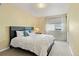 Bedroom featuring a dark bed frame with white comforter and pillows and a sunny window at 15962 W 70Th Dr, Arvada, CO 80007