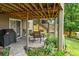 Covered outdoor patio with table and chairs, brick flooring, and an outdoor grill at 15962 W 70Th Dr, Arvada, CO 80007