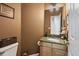 A charming powder room with a decorative mirror, granite countertop, and neutral tones at 15962 W 70Th Dr, Arvada, CO 80007