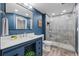 This renovated bathroom showcases a glass-enclosed shower and updated fixtures against a rich blue wall at 14431 Forest St, Thornton, CO 80602