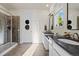 Bright bathroom features double vanity sinks, mirrors, and a glass enclosed shower with tile surround at 14431 Forest St, Thornton, CO 80602