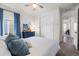 Bedroom with blue dresser, neutral carpet, large closet, and large bed with a blue accents at 14431 Forest St, Thornton, CO 80602