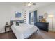 Stylish bedroom with accent wall art, dark wood dresser, neutral carpet, and a large window at 14431 Forest St, Thornton, CO 80602