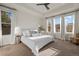 Bright bedroom features a large bed with neutral bedding, large windows, and soft, neutral colored carpet at 14431 Forest St, Thornton, CO 80602