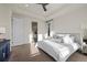 Bright bedroom features a large bed, carpet flooring, tray ceiling, and view into the bathroom at 14431 Forest St, Thornton, CO 80602