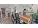 Bright dining room features wood table, black chairs, wood floors, and an adjacent kitchen with a black island at 14431 Forest St, Thornton, CO 80602