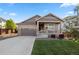Inviting home featuring a two-car garage, well-maintained lawn and a charming front porch at 14431 Forest St, Thornton, CO 80602