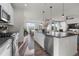 Bright kitchen featuring stainless steel appliances, a large island, and a view to the living room at 14431 Forest St, Thornton, CO 80602