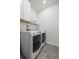 Efficient laundry room with modern washer and dryer units, maximizing space with overhead storage shelves at 14431 Forest St, Thornton, CO 80602