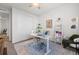 Bright home office with neutral rug, white desk, an accent chair and plenty of natural light at 14431 Forest St, Thornton, CO 80602