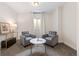 This cozy sitting room includes 2 grey armchairs and a marble-topped table at 14431 Forest St, Thornton, CO 80602