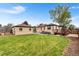 A large backyard with mature trees, a wooden deck, patio, and grassy yard at 3000 N Fillmore St, Denver, CO 80205