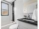 Well-lit bathroom with tiled walls, a shower, and a sleek black countertop at 3000 N Fillmore St, Denver, CO 80205