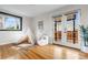 Bright living room with hardwood floors, teepee, white chair and access to the backyard through French doors at 3000 N Fillmore St, Denver, CO 80205