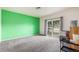 Bright living room featuring a sliding glass door with gray carpet and a contrasting green accent wall at 18038 Becket Dr, Parker, CO 80134