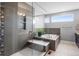 Modern bathroom featuring a glass shower, a soaking tub, and neutral tile at 11177 E 162Nd Pl, Brighton, CO 80602