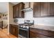 Modern kitchen with stainless steel appliances, granite counters, and dark wood cabinetry at 11177 E 162Nd Pl, Brighton, CO 80602