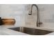 Close up of the kitchen sink featuring updated faucet, backsplash, and countertops at 11195 Alcott St # D, Westminster, CO 80234