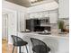 Bright kitchen featuring white cabinets, stainless steel appliances, and bar seating at 11195 Alcott St # D, Westminster, CO 80234