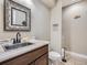 Charming powder room features granite counters, stainless steel sink, and ornate mirror at 7845 S Flat Rock Way, Aurora, CO 80016