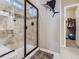 Modern bathroom with tiled walk-in shower featuring glass door and a decorative fish on the wall at 7845 S Flat Rock Way, Aurora, CO 80016