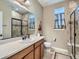 Well-lit bathroom features a large mirror, spacious vanity, and tiled shower with a glass door at 7845 S Flat Rock Way, Aurora, CO 80016