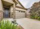 Inviting home with stone accents, front porch and convenient two-car garage with wide driveway at 7845 S Flat Rock Way, Aurora, CO 80016