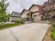 A charming home showcases its stone accents, complemented by a spacious driveway and verdant lawn at 7845 S Flat Rock Way, Aurora, CO 80016