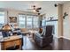 Relaxing living room with a fireplace, fan, leather seating and scenic outdoor views at 7845 S Flat Rock Way, Aurora, CO 80016