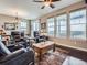 Cozy living room with a ceiling fan, large windows, leather furniture, and comfortable seating arrangement at 7845 S Flat Rock Way, Aurora, CO 80016