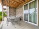 A covered patio featuring a brick wall, outdoor dining set, and sliding glass door at 7845 S Flat Rock Way, Aurora, CO 80016