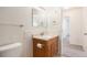 Bathroom featuring a vanity with storage, a toilet, and tiled accents, enhanced by ample natural light from the nearby doorway at 350 S Clinton St # 2A, Denver, CO 80247