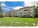 Well-maintained building with balcony, set against lush green lawn and blue sky at 350 S Clinton St # 2A, Denver, CO 80247